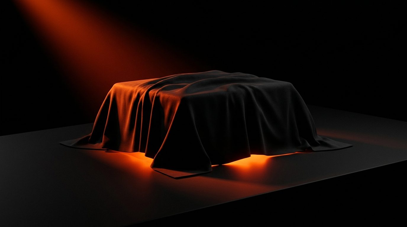 Drop 01 veiled beneath dark fabric with warm amber illumination leaking from the base